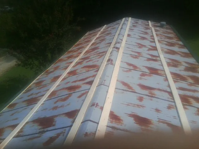 Rusted metal roof panels with new wood purlins before replacement — Storm Damage Roof Repair in Lakeshore by Roofing Brothers