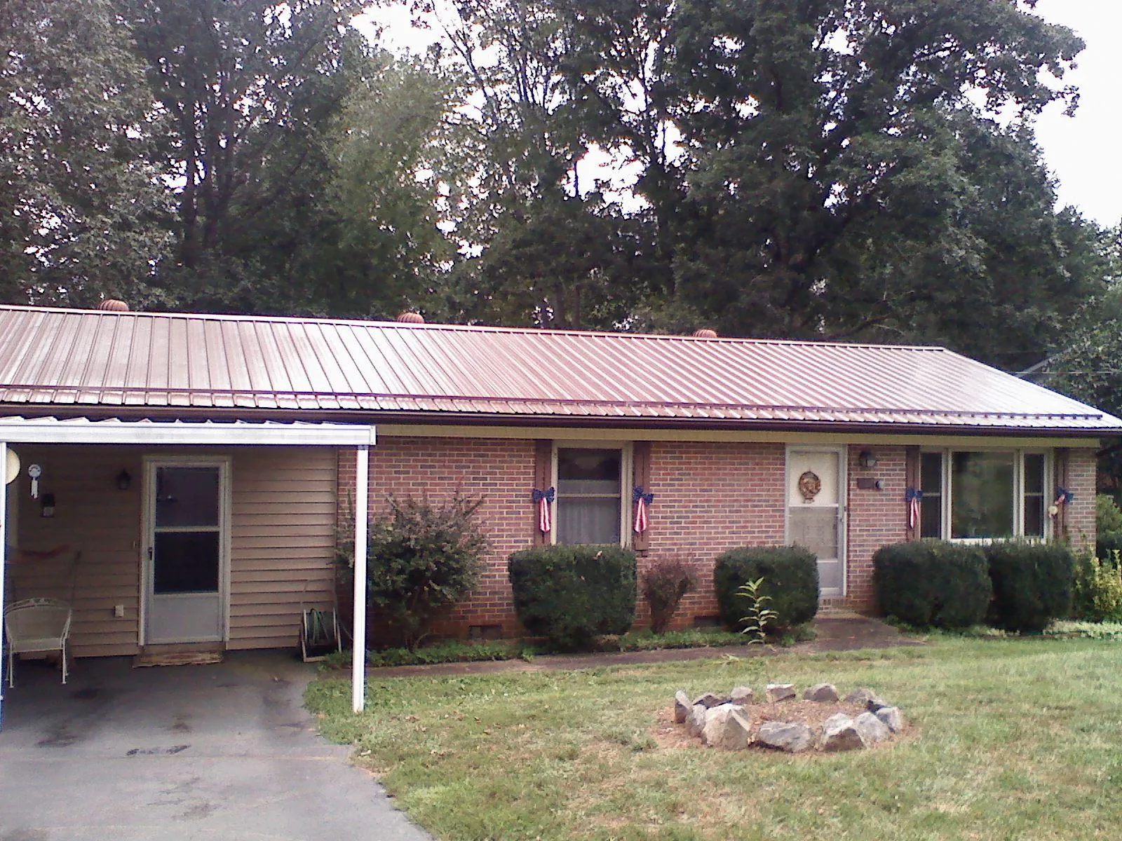 Bronze metal roof and carport on a brick ranch home — Roof Repair work by our crew in Lakeshore